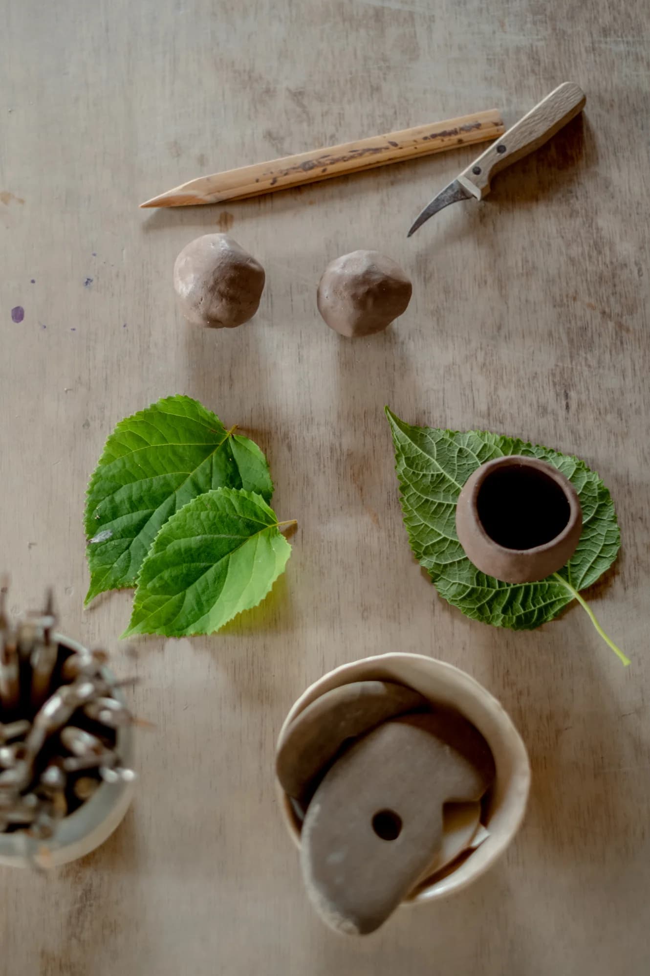 Hands working with wet clay on pottery wheel